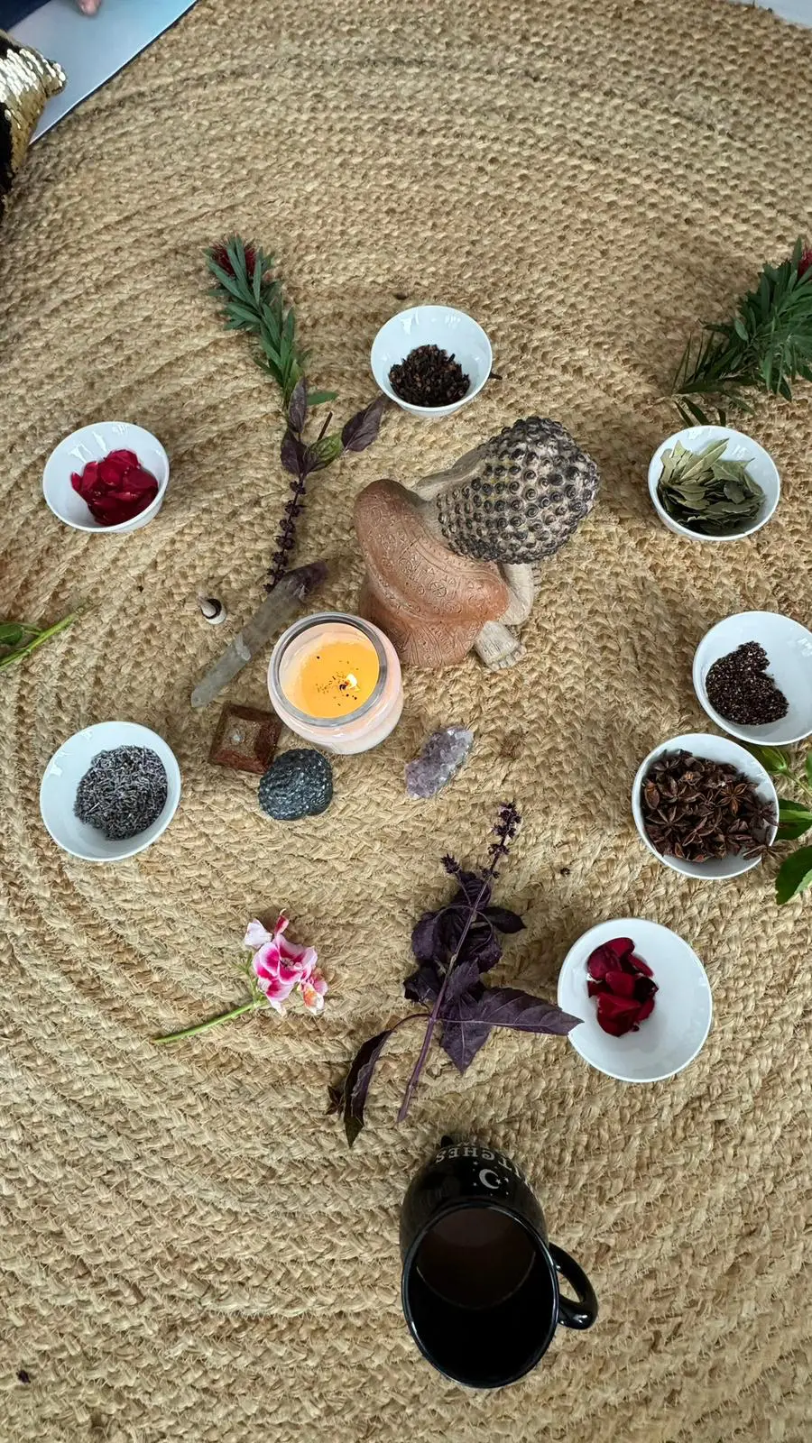 Crystals, herbs and a candle arranged for an integrative therapy session